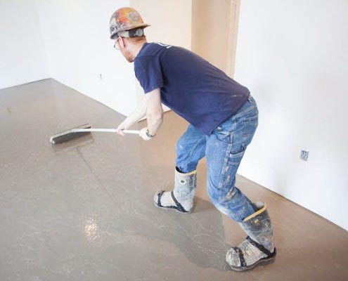 Guy preparing a floor surface for tiling