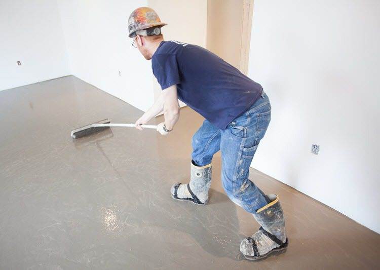 Guy preparing a floor surface for tiling